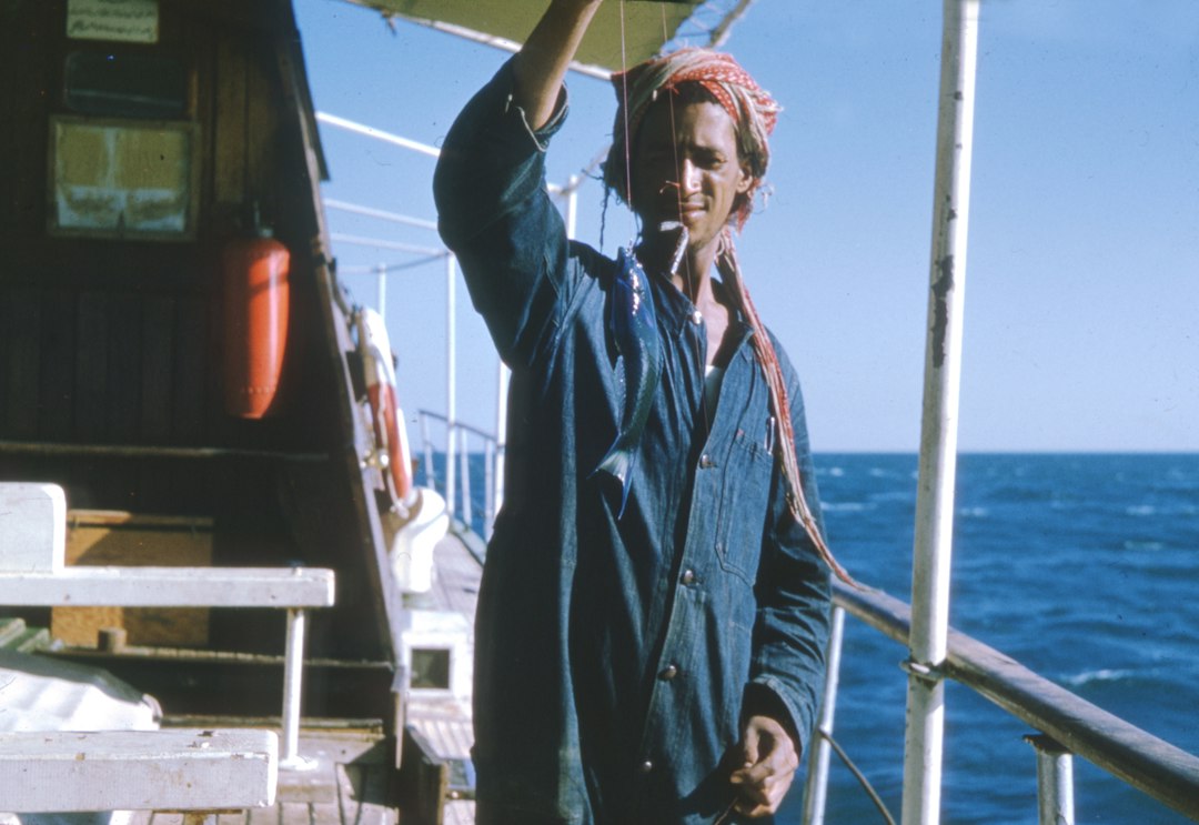 man in black jacket standing on boat during daytime